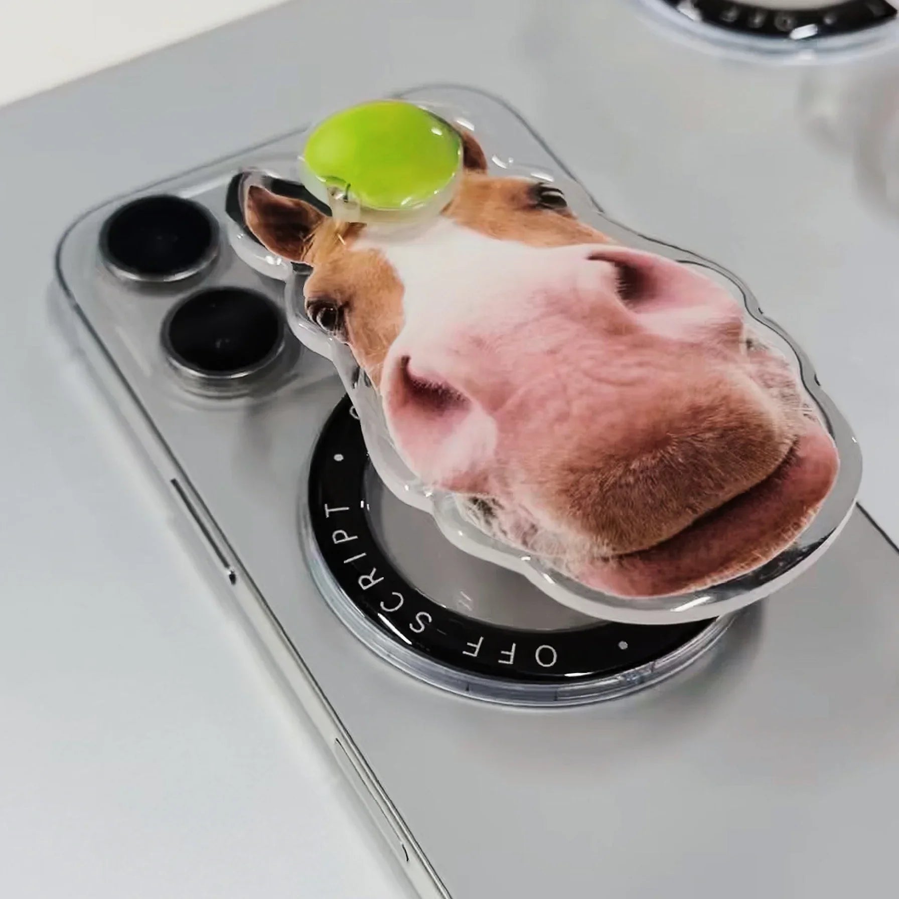 Green Apple-Horse MagSafe pop-up grip on silver iPhone, horse face with bright green apple on top